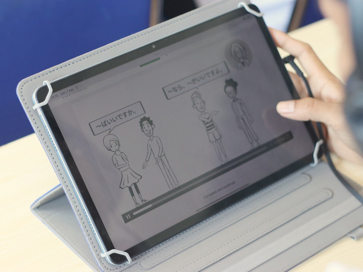 タブレットの画面に、日本語の会話の映像授業が映っている様子