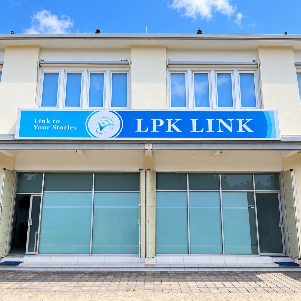 第2校舎の正面。2階建ての白い建物に、青い横長の LPK LINK の看板。1階はガラス張り